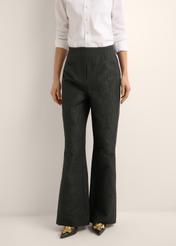 Czarne spodnie wide leg w kwiaty SPODT-0127-99(Z26), widok produktu z przodu na modelce. Widoczna połowa sylwetki.