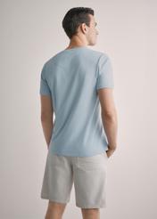 Niebieski bawełniany T-shirt męski TSHMT-0088-7A(W26), widok produktu z tyłu na modelu. Widoczna połowa sylwetki.