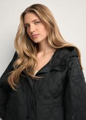 Czarna krótka pikowana kurtka oversize KURDT-0660-99(W26) - widok produktu z przodu, na modelce, na jasnym tle. Widoczne zbliżenie. 