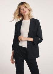 Czarna marynarka damska bez zapięcia ZAKDT-0034-99(Z24) - widok produktu z przodu na modelce na białym tle. Widoczna połowa sylwetki. 