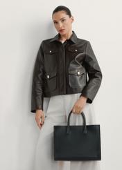 Skórzana torebka damska w kolorze czarnym TORES-1206-9I(W26), widok produktu w dłoni modelki. Widoczna połowa sylwetki.