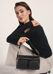Czarna skórzana torebka damska TORES-1161-99(Z25) -widok produktu z przodu na modelce na białym tle. Widoczna połowa sylwetki.