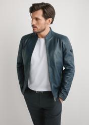 Granatowa skórzana kurtka męska KURMS-0329-7E(W26) - widok produktu z przodu, na modelu, na jasnym tle. Widoczna sywletka do kolan. 