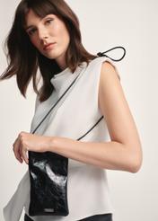 Czarna saszetka z połyskiem TOREC-1114-99(Z25), widok produktu od przodu na modelce, widoczna połowa sylwetki.