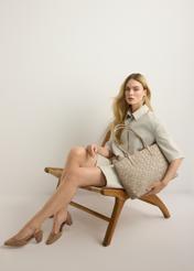 Duża jasnobeżowa torebka damska z plecionką TOREC-1168-1A(W26), widok produktu w dłoni modelki. Widoczna cała sylwetka.