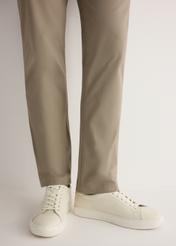 Białe skórzane buty sportowe BUTYM-0503A-0B(W26), widok produktu od boku na modelce, widoczna połowa sylwetki.