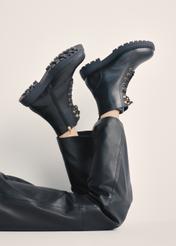Czarne skórzane botki damskie BUTYD-1015A-99(Z25), widok produktu na stopach modelki na jasnym tle.