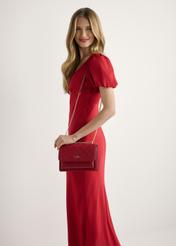 Czerwona torebka damska z monogramem TOREC-1155-4B(W26), widok produktu od przodu na modelce, widoczna połowa sylwetki.