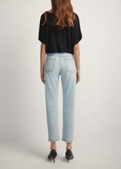 Jasnoniebieskie spodnie jeansowe damskie JEADT-0011-7A(W26), widok produktu z tyłu na modelce. Widoczna połowa sylwetki.