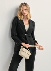 Kremowa mała torebka damska na ramię TOREC-0916-0B(W26), widok produktu na sylwetce modelki.