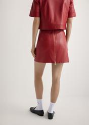 Czerwona skórzana spódnica damska mini SPCDS-0081-4B(W26), widok produktu od tyłu na modelu, widoczna połowa sylwetki.