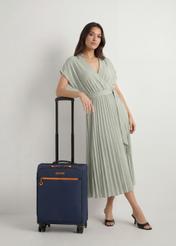 Walizka średnia na kółkach WALNY-0045-7D-24(W26), widok produktu z przodu obok sylwetki modelki.