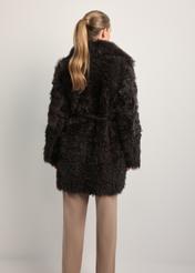 Brązowy dwustronny skórzany kożuch damski KOZDS-0090-1393(Z25), widok produktu z tyłu na modelce. Widoczna połowa sylwetki.