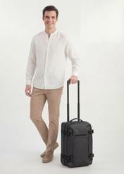 Walizka mała na kółkach WALNY-0047-99-19(W26), widok produktu skosem obok sylwetki modela.