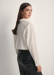 Biała bawełniana koszula damska KOSDT-0181-0A(W26), widok produktu od tyłu na modelce, widoczna połowa sylwetki.