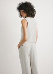 Kamizelka damska z wiskozy KAMDT-0037-0P(W26) - widok produktu z tyłu, na modelce, na jasnym tle. Widoczna sylwetka do kolan. 