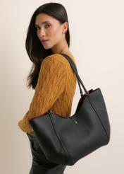 Czarna torebka damska typu shopper TOREC-1296-9I(Z26), widok produktu z przodu, na modelce, na jasnym tle. Widoczna połowa sylwetka.