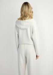 Jasnobeżowa bluza damska z kapturem BLZDT-0111A-1A(W26), widok produktu z tyłu na modelce. Widoczna połowa sylwetki.