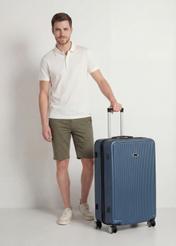 Walizka duża na kółkach WALAB-0053-7D-29(W26), widok produktu skosem przy modelu, widoczna cała sylwetka.