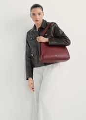 Ciemnoczerwona skórzana damska torebka shopper TORES-0636D-4C(W26) - widok produktu lekko po skosie, na modelce, na jasnym tle. Widoczna cała cała sylwetka.