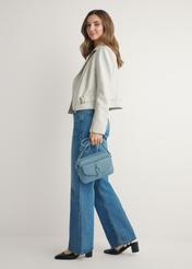 Niebieska mała torebka damska TOREC-1175-7C(W26) - widok produktu z przodu, na modelce, na jasnym tle. Widoczna cała sylwetka. 