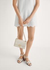 Skórzane sandały damskie w kolorze kremowym BUTYD-1177-0B(W26) - widok produktu z przodu, na modelce, na jasnym tle. Widczona sylwetka do połowy.