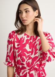 Sukienka w różowe kwiaty z wiskozy SUKDT-0271-5P(W26), widok produktu z przodu na modelce. Widoczna połowa sylwetki.