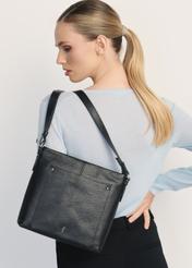 Czarna skórzana torebka damska TORES-1157-99(Z25) - widok produktu na modelce na białym tle. Widoczna połowa sylwetki.