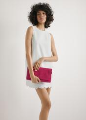 Zamszowa różowa torebka damska TORES-1247-5E(W26) - widok produktu z przodu, trzymanego przez modelkę w ręku, na jasnym tle. Widoczna połowa sylwetki. 