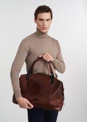Brązowa skórzana duża torba męska TORMS-0103-1H(W26), widok produktu rękach modela, na jasnym tle.