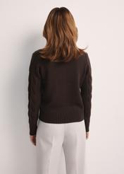 Czekoladowy sweter damski z ozdobnym splotem SWEDT-0210-90(Z25), widok produktu z tyłu na modelce. Widoczna połowa sylwetki.