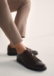 Brązowe skórzane buty męskie BUTYM-0513-89(Z25), widok produktu na stopach modela na jasnym tle.
