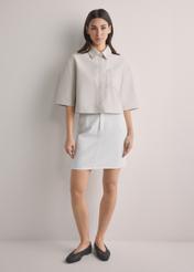 Kremowa denimowa spódnica mini SPCDT-0126-0B(W26), widok produktu z przodu na modelce. Widoczna cała sylwetka.