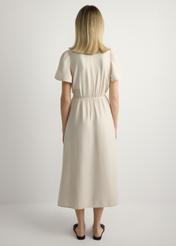 Sukienka damska w kolorze jasnego beżu SUKDT-0255-1A(W26), widok produktu z tyłu na modelce. Widoczna cała sylwetka.