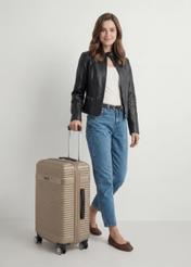 Walizka średnia na kółkach WALAB-0040-2X-24(W26), widok produktu skosem przy modelce, widoczna cała sylwetka.