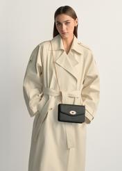 Czarna mała torebka damska TOREC-1141-9I(W26), widok produktu na ramieniu modelki. Widoczna połowa sylwetki.