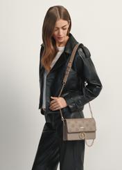 Ciemnobeżowa torebka damska z monogramem TOREC-0536-1K(W26), widok produktu od przodu na modelce, widoczna połowa sylwetki.