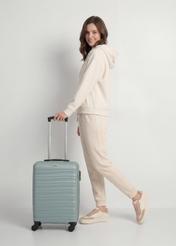 Walizka mała na kółkach WALAB-0081-8F-19(W26), widok produktu z przodu obok sylwetki modelki.