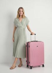 Walizka duża na kółkach WALAB-0053-5C-29(W26), widok produktu skosem obok sylwetki modelki.