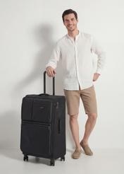 Walizka duża na kółkach WALNY-0048-99-28(W26), widok produktu skosem obok sylwetki modela.