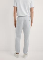 Szare dresowe spodnie męskie SPOMT-0116-9A(W26), widok produktu z tyłu na modelu. Widoczna połowa sylwetki.