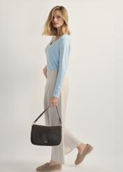 Czarna skórzana listonoszka damska TORES-1253-99(W26), widok produktu w dłoni modelki. Widoczna cała sylwetka.