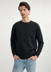 Czarna bluza męska bez kaptura BLZMT-0070-99(W25) - widok z przodu na modelu na białym tle. Widoczna połowa sylwetki. 