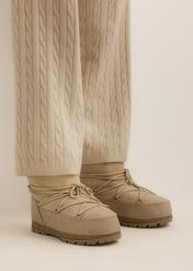 Śniegowce damskie w kolorze chłodnego beżu BUTYD-1315-1K(Z26), widok produktu z boku na stopach modelki, na jasnym tle.