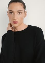 Czarna sukienka damska SUKDT-0260-99(W26), widok produktu od przodu na modelce, zbliżenie na twarz.