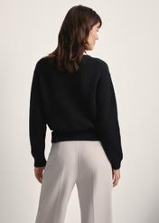 Czarny sweter damski SWEDT-0238-99(Z25), widok produktu z tyłu na modelce. Widoczna połowa sylwetki.