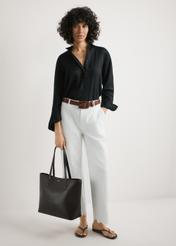 Brązowa damska torebka shopper TOREC-1235-1H(W26),  widok produktu w rękach modelki. Widoczna cała sylwetka.