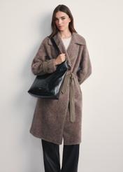 Czarna damska torebka shopper TOREC-1086-99(Z25) - widok produktu z przodu na modelce na białym tle. Widoczna cała sylwetka. 