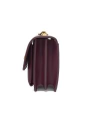 Mała bordowa torebka damska z eleganckim zapięciem TOREC-1322-4D(Z26), widok produktu z boku na białym tle.