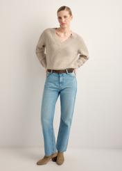 Sweter damski w kolorze chłodnego beżu SWEDT-0162-1J(Z26), widok produktu z przodu na modelce. Widoczna cała sylwetka. 